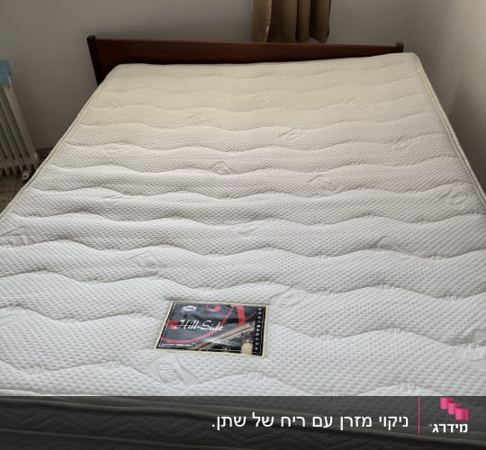 מזרן לבן עם תווית על מיטה בחדר שינה